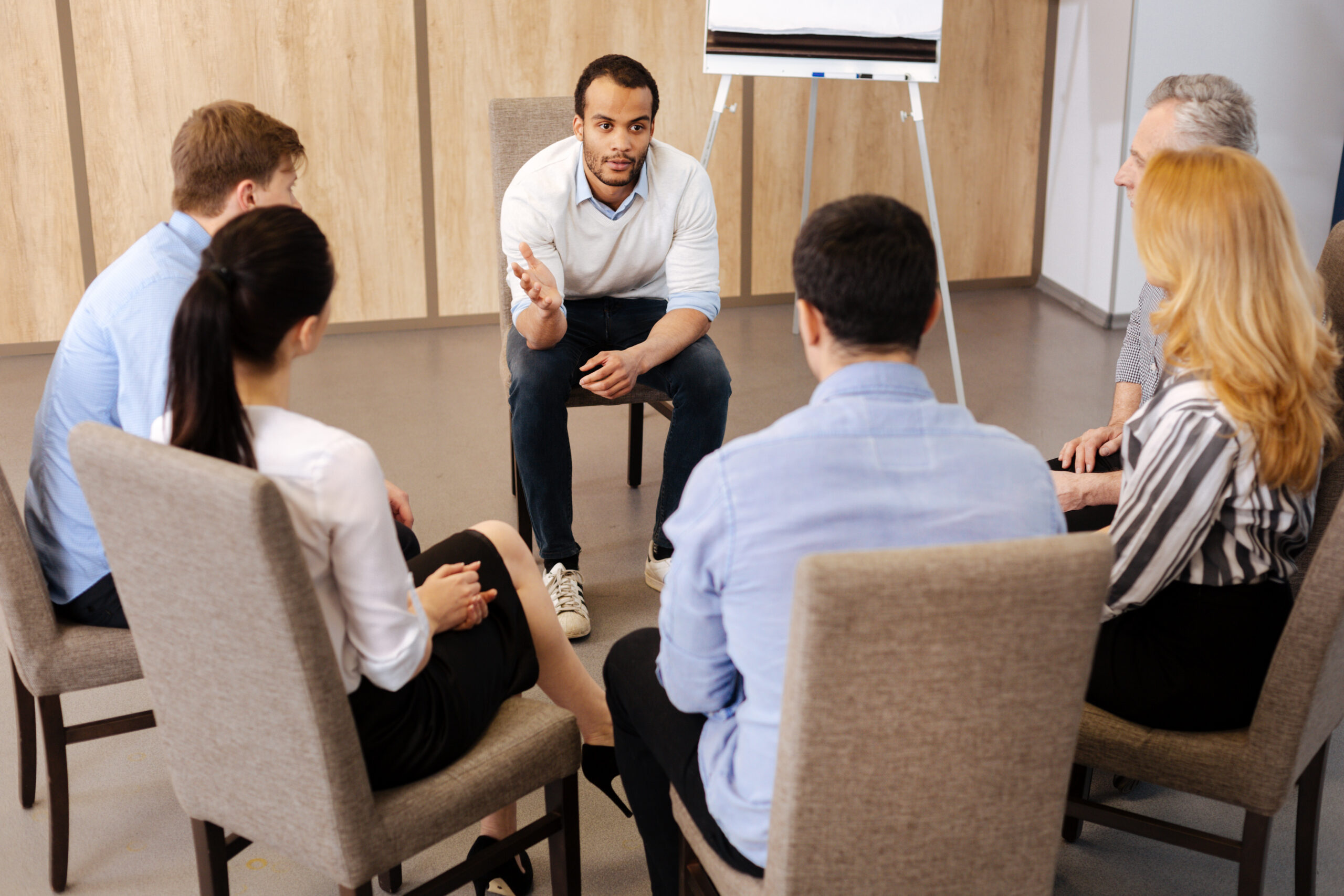 Therapist talking to a family sitting in a circle.